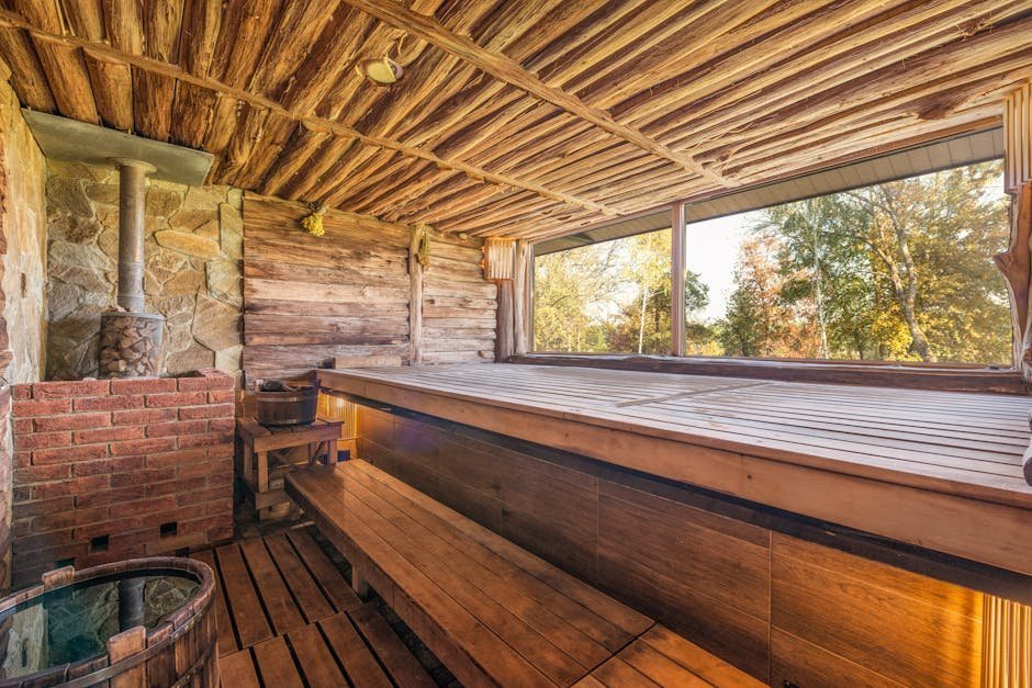 Wood-paneled traditional Finnish sauna interior with heated stones and bucket of water