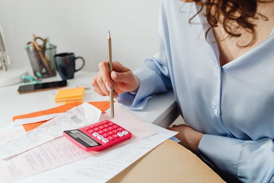 Patient organizing medical bills and tax forms at kitchen table preparing financial assistance paperwork