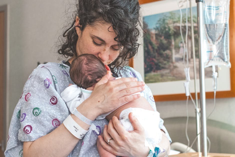Mother holding newborn baby in postpartum recovery program with peer support specialist