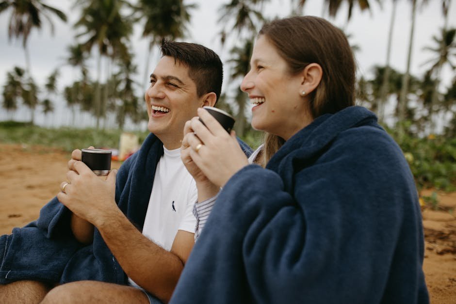 Two adults laughing together at outdoor coffee shop, building friendship over conversation in afternoon light