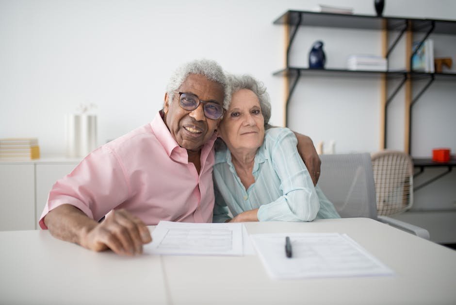 Couple sitting together at kitchen table reviewing budget and finances, having calm money conversation