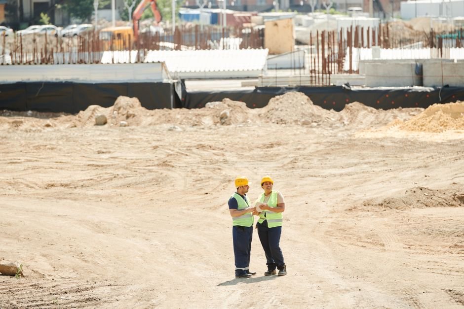 A civil engineering student reviewing plans at a construction site